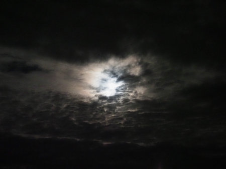 dramatic sky with moonlight shining from behind the cloudsの写真素材