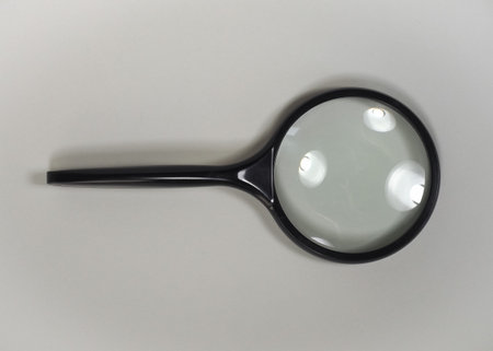magnifying glass over a light gray backgroundの写真素材