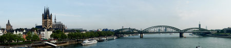 Koelner Dom Sankt Petrus (meaning St Peter Cathedral) gothic church and Hohenzollernbruecke (meaning Hohenzollern Bridge) crossing the river Rhein, panoramic view in Koeln, Germanyの写真素材