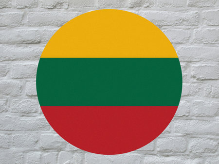 round Lithuanian national flag of Lithuania, Europe over white bricks wallの写真素材