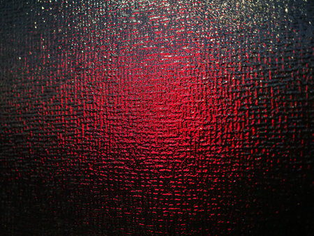 red light behind translucent red glass texture useful as a backgroundの写真素材