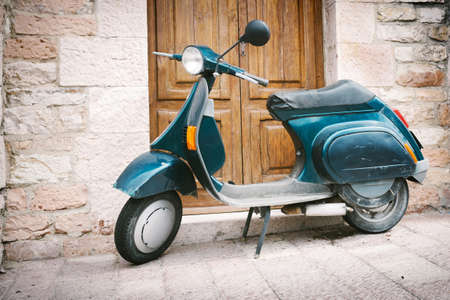 Old Italian scooter in front of the doorの写真素材