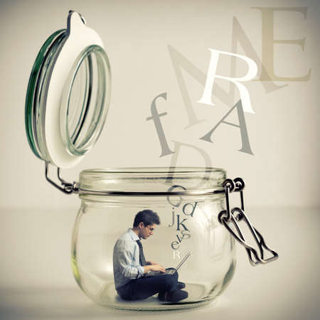 young man with laptop in a glass jarの写真素材