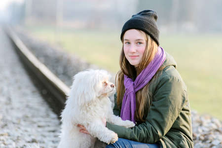 Teen girl with her dog on the rails