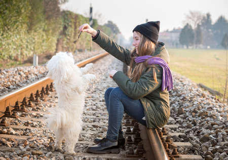 Teen girl with her dog on the railsの写真素材
