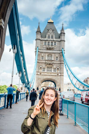 Teen girl making the sign do win on the tower bridge - London UKのeditorial素材