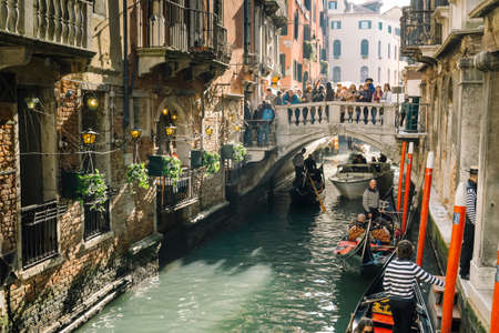 Venice, Italy - February 27, 2017: Tourists travel on gondolas at canal. Gondola trip is the most popular touristic activity in Venice.のeditorial素材