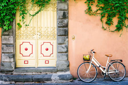 Colorful entrance door and bicycle in tuscanyの写真素材