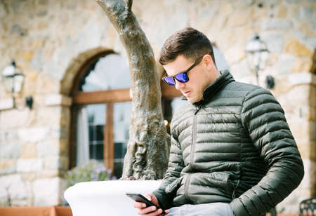 Young man outdoor who is using the mobile phone