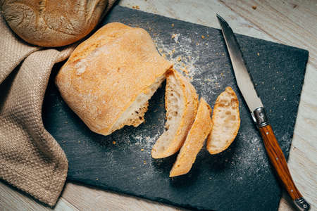 homemade fresh sliced bread on slate cutting board