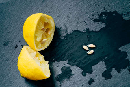 fresh lemons with green leaves on slate cutting boardの写真素材