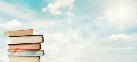Stack of books silhouetted against bright spring skyの写真素材