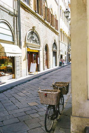 Florence, Italy - August 25, 2020: bicycle with straw baskets leaning on the wall of an alley in Florenceのeditorial素材