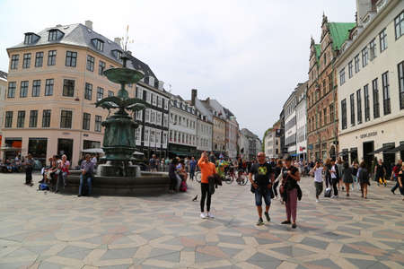 Crowds of shoppers and tourists enjoying the sunshine in the street of Copenhagen