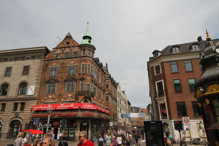 Crowds of shoppers and tourists enjoying the sunshine in the street around the Stork Fountain in the Amagertorv shopping district in the heart of Copenhagenのeditorial素材