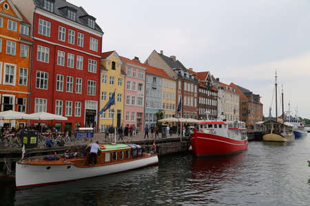 People visit cafes and bars on the colourful Nyhavn harbour front in Copenhagen, Denmarkのeditorial素材