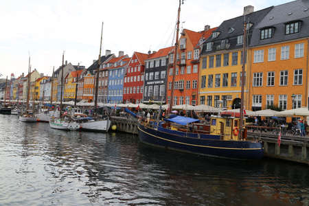 People visit cafes and bars on the colourful Nyhavn harbour front in Copenhagen, Denmarkのeditorial素材