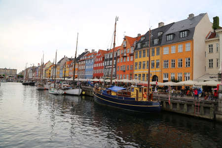 People visit cafes and bars on the colourful Nyhavn harbour front in Copenhagen, Denmarkのeditorial素材