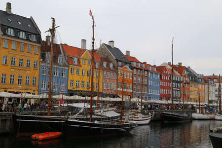 People visit cafes and bars on the colourful Nyhavn harbour front in Copenhagen, Denmarkのeditorial素材