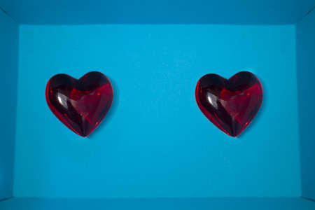 two separate red hearts on each side of a deep blue backgroundの写真素材
