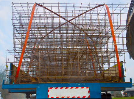 Picture form behind of an trailer, fully loaded with construction material securized with tow orange...