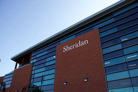 Oakville, Ontario / Canada - September 11, 2020: Sheridan College sign on red brick wall and glass at the Trafalgar Campus, currently closed due to Covid-19 pandemic.のeditorial素材
