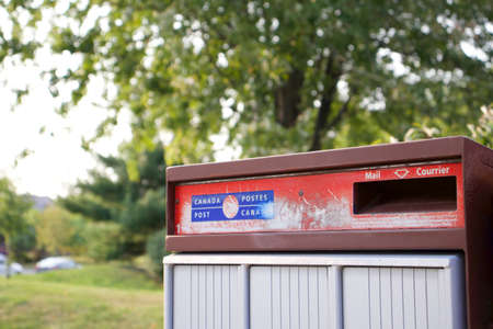 Oakville, Ontario / Canada - September 16, 2020: A Selective Focus Close up of a receiving red mailbox of Canada Post. (Postes Canada). It is a Crown corporation.のeditorial素材