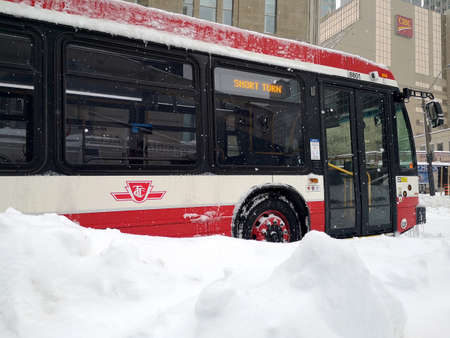 Toronto, Ontario - Canada - January 17, 2022:  TTC Toronto Transit Commission bus stuck in more than a foot of snow. Public transportation disruption during a historic snowstorm blizzard.のeditorial素材