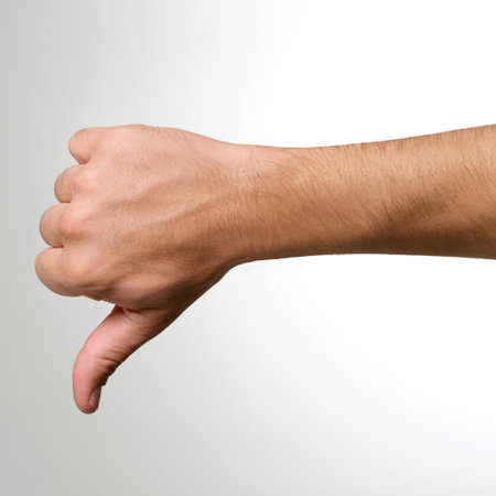 Male hand showing thumb down sign isolated on white background, close up
