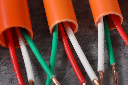 Close up of electrical cables in orange and green color on gray backgroundの写真素材