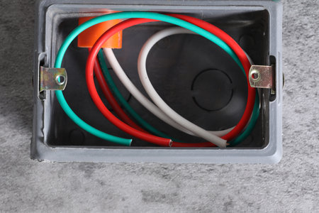 Electrical box with multicolored wires on gray background, top viewの写真素材