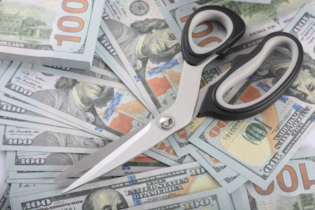 Scissors on money background, close-up. Business concept.の写真素材