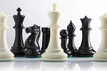 Black and white chess figures on a white background, close-upの写真素材