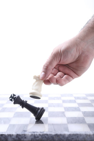 Chess concept - man playing chess on a chessboard with white backgroundの写真素材