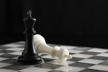 Black and white chess king on a chessboard with black background.