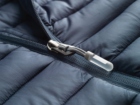 Close up of a zipper in a blue jacket. Selective focus.