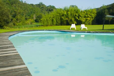 Pool surrounded by greenery in a relaxing and sunny setting at sunsetのeditorial素材
