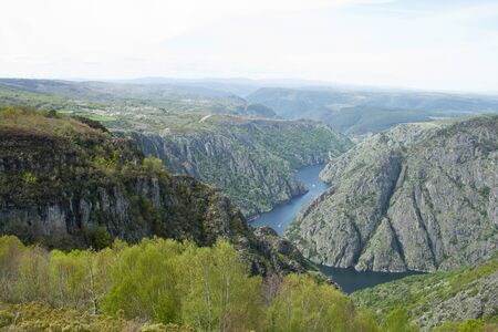 River at the bottom of a canyon with a boat sailing its waters. Sil river between Lugo and Orense provinces in Galicia region, Spain.のeditorial素材