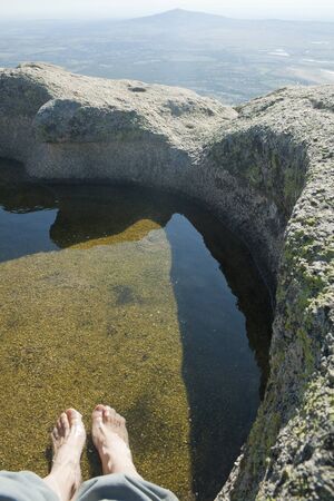 Relaxing foot bath in a natural granite pool on the top of a mountain.