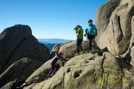 Manzanares el Real, Spain - January 11, 2020: Woman climbing while another woman photographs her a...