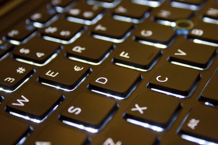 illuminated laptop keyboard with black keysの写真素材