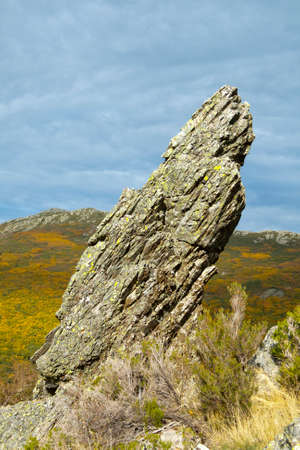Rock escarpment with background autumnal oak, with cloudy sky. Riofrio, Segovia.の写真素材