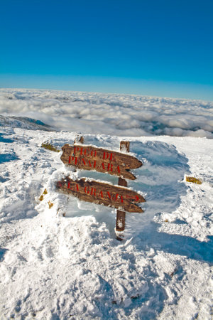 banner covered in snow and frozen in the wind. PeÃ±alara summit in the Sierra de Guadarrama national park in Madrid, Spainの写真素材