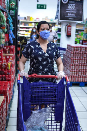 June 10th, 2020. Madrid Spain. Caucasian woman doing shopping in a super market in a blue dress...