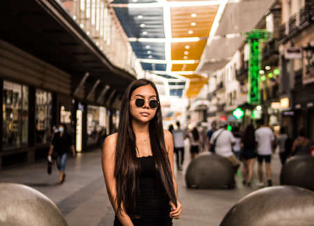 Selective focus of young hispanic woman posing on a summer day while strolling through the cityの写真素材