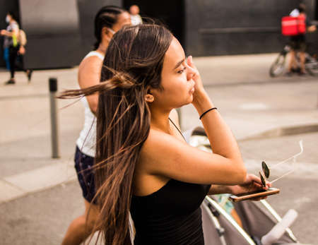 Selective focus of young hispanic woman posing on a summer day while strolling through the cityの写真素材