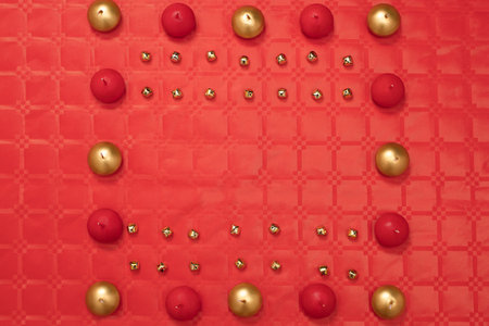Chinese new year decoration with red and gold ornaments, two color candles on a red table with red...