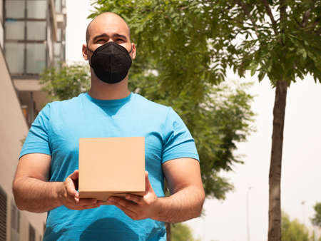 Caucasian man in uniform of postman or courier delivery man or parcels entering door and streetsの写真素材