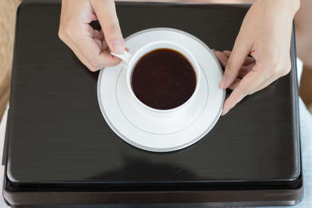 A pair of women's hands holding a cup of Coffeeの写真素材