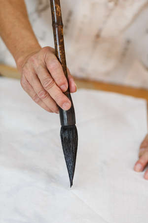 Writing Chinese calligraphy scene,Old man holding a brushの写真素材